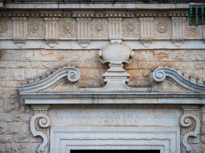 Quest�ultimo � racchiuso da una cornice scanalata sormontata a sua volta da due volute affrontate e da un architrave su cui leggiamo l�anno di fondazione della chiesa, il 1664